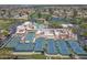 Aerial view showcases the tennis courts, a pool, and the community center amidst a well-kept landscape at 9847 E Michigan Ave, Sun Lakes, AZ 85248