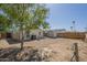 Wide shot of backyard featuring desert landscaping, utility shed, privacy fence, and mature tree at 10951 N 91St Ave # 32, Peoria, AZ 85345
