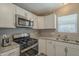 Well-lit kitchen featuring granite counters, stainless steel appliances, and white cabinets at 10951 N 91St Ave # 32, Peoria, AZ 85345