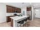 Well-lit kitchen features stainless steel appliances, a spacious island, and dark wood cabinetry at 10983 W Mckinley St, Avondale, AZ 85323