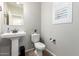 Well-lit powder room featuring a pedestal sink, toilet, and window with bright natural light at 10983 W Mckinley St, Avondale, AZ 85323