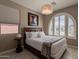 Bright bedroom with a large window, decorative light fixture, and queen bed at 132 E El Prado Dr, Queen Creek, AZ 85140
