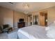 Spacious primary bedroom with tiled floor, pendant light, sitting chair, and TV at 132 E El Prado Dr, Queen Creek, AZ 85140