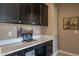 A home office features dark cabinets with a white countertop and laptop on the counter at 132 E El Prado Dr, Queen Creek, AZ 85140