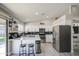 Well-lit kitchen boasts white cabinets, stainless steel appliances, black backsplash, a breakfast bar and modern light fixtures at 1529 W Wickieup Ln, Phoenix, AZ 85027