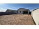 Rear exterior of house with dirt backyard and privacy wall at 15773 W Beryl Ave, Waddell, AZ 85355