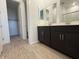 Modern bathroom with dual vanities, wood look tile flooring, and a walk in shower at 15773 W Beryl Ave, Waddell, AZ 85355