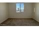 An empty bedroom with a window, neutral paint, and carpeted floor at 15773 W Beryl Ave, Waddell, AZ 85355
