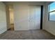 An empty bedroom with a closet, window, neutral paint, and carpeted floor at 15773 W Beryl Ave, Waddell, AZ 85355