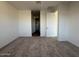 Spacious bedroom with neutral carpet, white walls, and a glimpse into the closet at 15773 W Beryl Ave, Waddell, AZ 85355