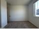 A carpeted, empty bedroom with a window and neutral paint at 15773 W Beryl Ave, Waddell, AZ 85355