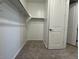 Walk in closet with clothing racks, carpet flooring, and white door at 15773 W Beryl Ave, Waddell, AZ 85355