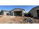 View of a single-story stucco home with tile roof and open garage at 15773 W Beryl Ave, Waddell, AZ 85355