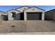 A single-story home with a two-car garage, gravel yard and a paved driveway at 15773 W Beryl Ave, Waddell, AZ 85355