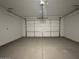 A clean, empty two car garage with a sealed concrete floor at 15773 W Beryl Ave, Waddell, AZ 85355