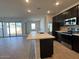 Modern kitchen with stainless appliances and breakfast bar opening to the living area at 15773 W Beryl Ave, Waddell, AZ 85355