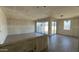 Spacious unfinished living room featuring stylish flooring, drywall walls, and sliding door access to the backyard at 15773 W Beryl Ave, Waddell, AZ 85355