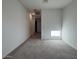 Large, airy living room with neutral carpet and freshly painted white walls at 15773 W Beryl Ave, Waddell, AZ 85355