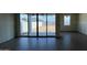 Living room with wood flooring and sliding glass doors to backyard at 15773 W Beryl Ave, Waddell, AZ 85355