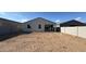 Rear exterior of house with dirt backyard and privacy wall at 15773 W Beryl Ave, Waddell, AZ 85355