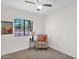 Bright bedroom with a ceiling fan, carpet floors, and a street view through a large window at 16421 N 65Th Pl, Scottsdale, AZ 85254
