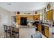 Well-lit kitchen featuring light wood cabinets, black appliances, and island with bar seating at 16450 E Ave Of The Fountains -- # 14, Fountain Hills, AZ 85268