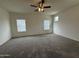 Spacious bedroom featuring neutral carpeting, a ceiling fan, and windows that provide natural light at 1734 W Pollack St, Phoenix, AZ 85041