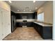 A modern kitchen features sleek, dark cabinetry and stainless steel appliances, complemented by granite countertops at 1734 W Pollack St, Phoenix, AZ 85041