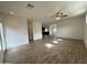 Large open-concept living area with wood-look flooring and fan, kitchen in the background at 1734 W Pollack St, Phoenix, AZ 85041