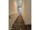 Interior view of a carpeted staircase leading down to a tiled floor with white walls and handrail at 1734 W Pollack St, Phoenix, AZ 85041