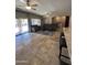 Open-concept living room with travertine floors, neutral decor, and sliding door to backyard at 17447 W Yavapai St, Goodyear, AZ 85338