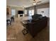 Open-concept living room with travertine floors, ceiling fans, and slider doors to the backyard at 17447 W Yavapai St, Goodyear, AZ 85338