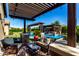 Inviting backyard with a sparkling pool, outdoor kitchen, comfortable seating and pergola for a relaxing outdoor living space at 17673 E Bronco Dr, Queen Creek, AZ 85142