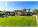 Expansive backyard with lush lawn, mature landscaping, and covered patio at 17673 E Bronco Dr, Queen Creek, AZ 85142