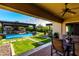 Serene backyard featuring a pool, outdoor kitchen and dining with lush landscaping, great for relaxation and outdoor living at 17673 E Bronco Dr, Queen Creek, AZ 85142