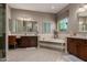 Elegant bathroom featuring a soaking tub, dual vanities, and a separate make-up vanity area at 17673 E Bronco Dr, Queen Creek, AZ 85142