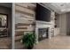 Elegant fireplace with stone surround, a mounted flat-screen TV, and decorative plant at 17673 E Bronco Dr, Queen Creek, AZ 85142