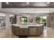 An airy kitchen featuring stainless steel appliances, a farmhouse sink and a large breakfast bar with backyard views at 17673 E Bronco Dr, Queen Creek, AZ 85142