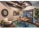 Home office with exposed beams, a ceiling fan, built-in shelving, and a decorative area rug at 17673 E Bronco Dr, Queen Creek, AZ 85142