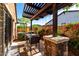 Cozy patio area with pergola offering a relaxing spot for outdoor seating and dining, next to beautiful landscaping at 17673 E Bronco Dr, Queen Creek, AZ 85142
