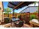 Charming patio area with outdoor seating under a pergola, surrounded by lush landscaping for a peaceful retreat at 17673 E Bronco Dr, Queen Creek, AZ 85142