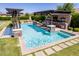Inviting pool area with stone pillars, lounge chairs, an outdoor kitchen, and a covered pergola at 17673 E Bronco Dr, Queen Creek, AZ 85142