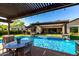 Sparkling pool with lush landscaping and a nearby outdoor kitchen and dining area, great for backyard entertainment at 17673 E Bronco Dr, Queen Creek, AZ 85142