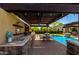 Pool area featuring a covered outdoor kitchen, dining set and lounge chairs perfect for entertaining Gathering and friends at 17673 E Bronco Dr, Queen Creek, AZ 85142