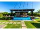 Inviting pool with swim up bar, covered patio, and manicured landscaping at 17673 E Bronco Dr, Queen Creek, AZ 85142