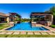 Resort-style pool area with pergola, outdoor kitchen, and beautiful water feature at 17673 E Bronco Dr, Queen Creek, AZ 85142