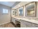 Bright bathroom boasts granite counters, a three-sink vanity, and decorative mirrors at 1871 Leisure World --, Mesa, AZ 85206