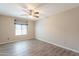Spacious bedroom with wood-look flooring, a ceiling fan, and a window for natural light at 1871 Leisure World --, Mesa, AZ 85206