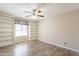 Comfortable bedroom features custom built-in shelving, wood-look floors, and a ceiling fan at 1871 Leisure World --, Mesa, AZ 85206