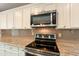 Stainless steel microwave and electric range oven appliances with granite countertops and neutral backsplash at 1871 Leisure World --, Mesa, AZ 85206